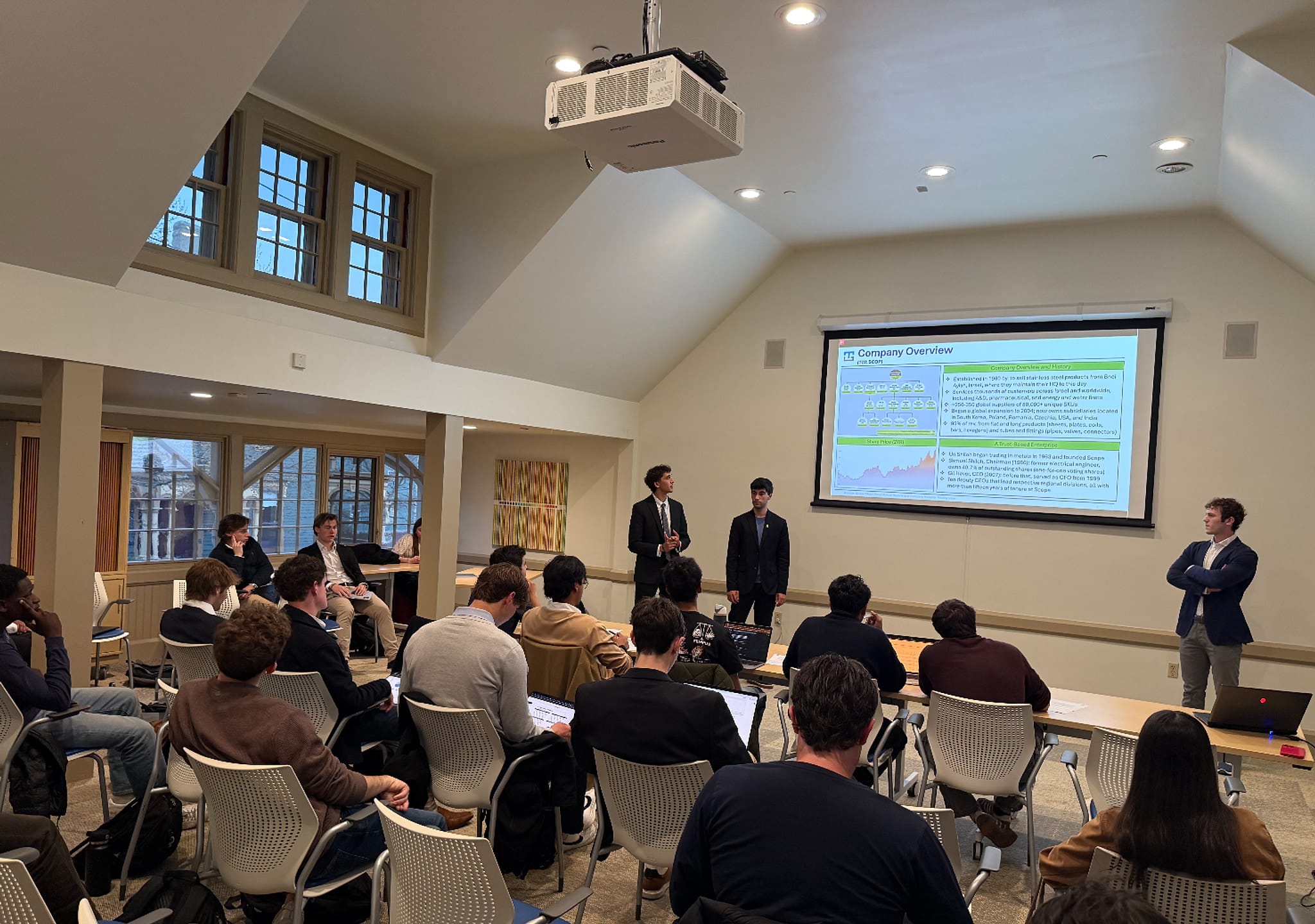 Two TAMID@Brown members in suits presenting a stock pitch to a room of members