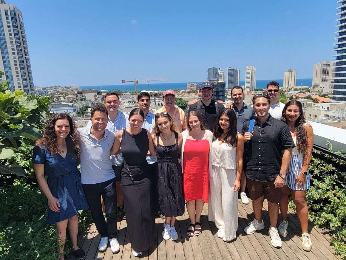 TAMID Fellows on a rooftop in Tel Aviv with the Mediterranean behind them