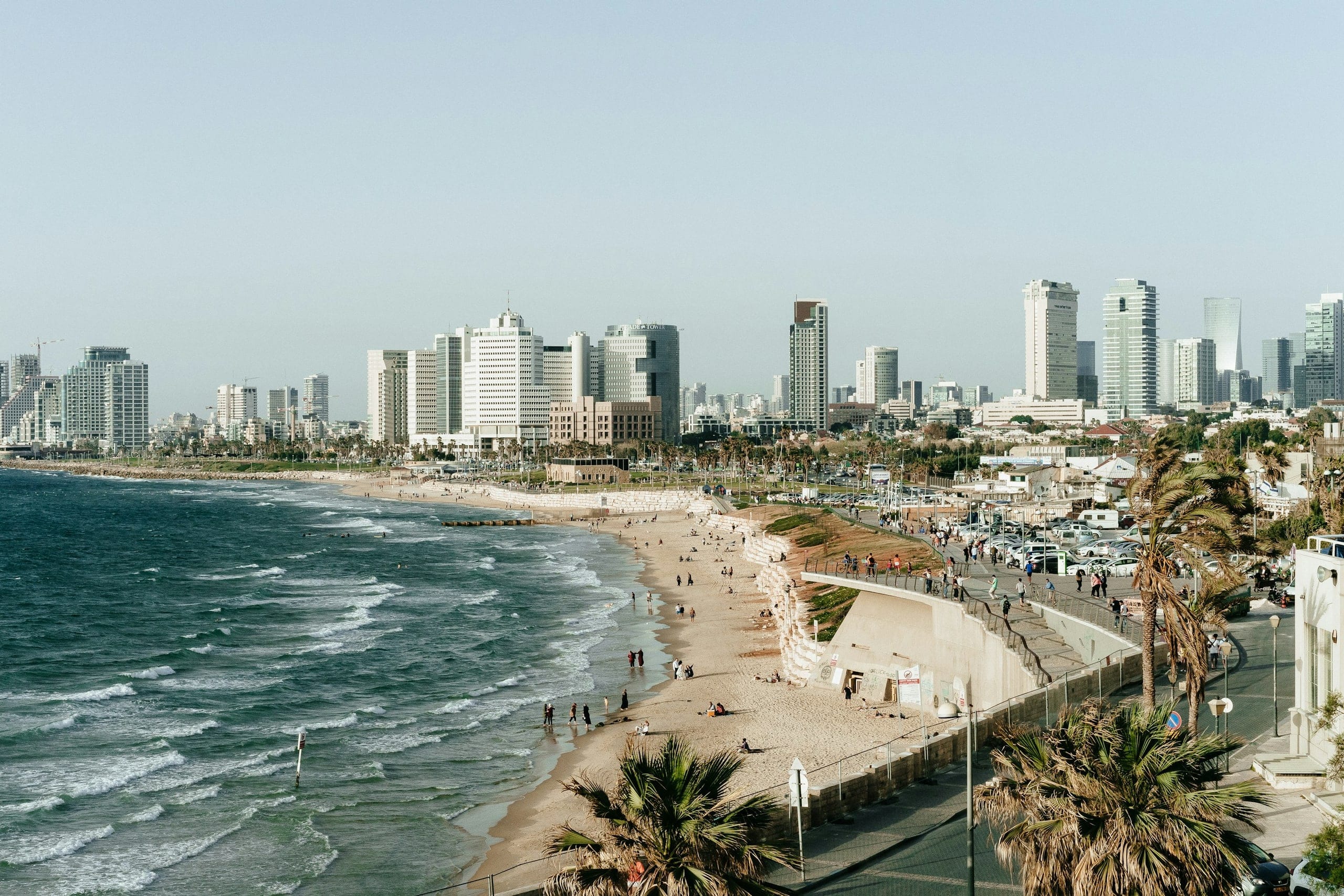Tel Aviv's beach and seaside promenade with the city skyline behind it